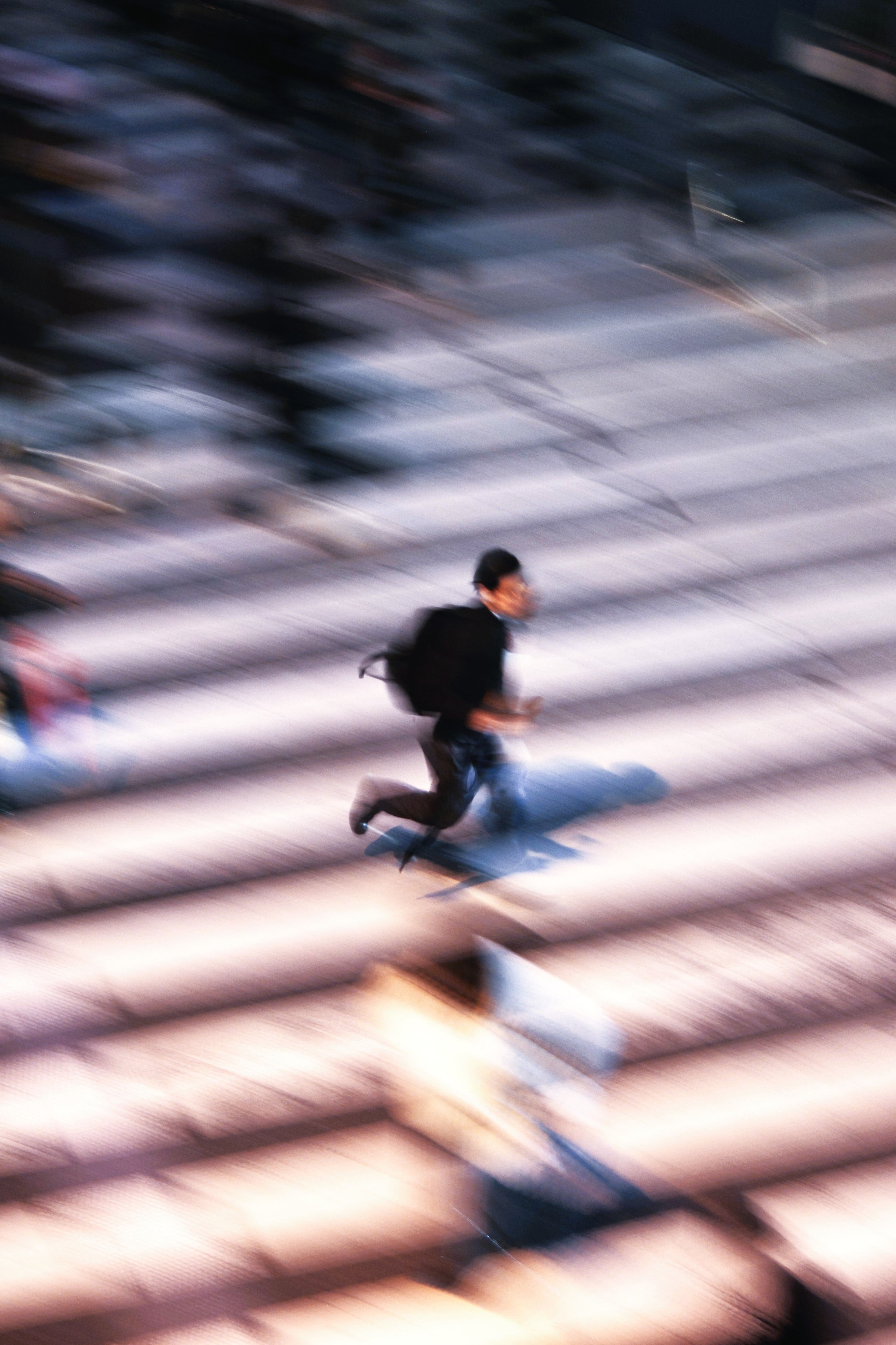 Person running through a city crosswalk in motion blur